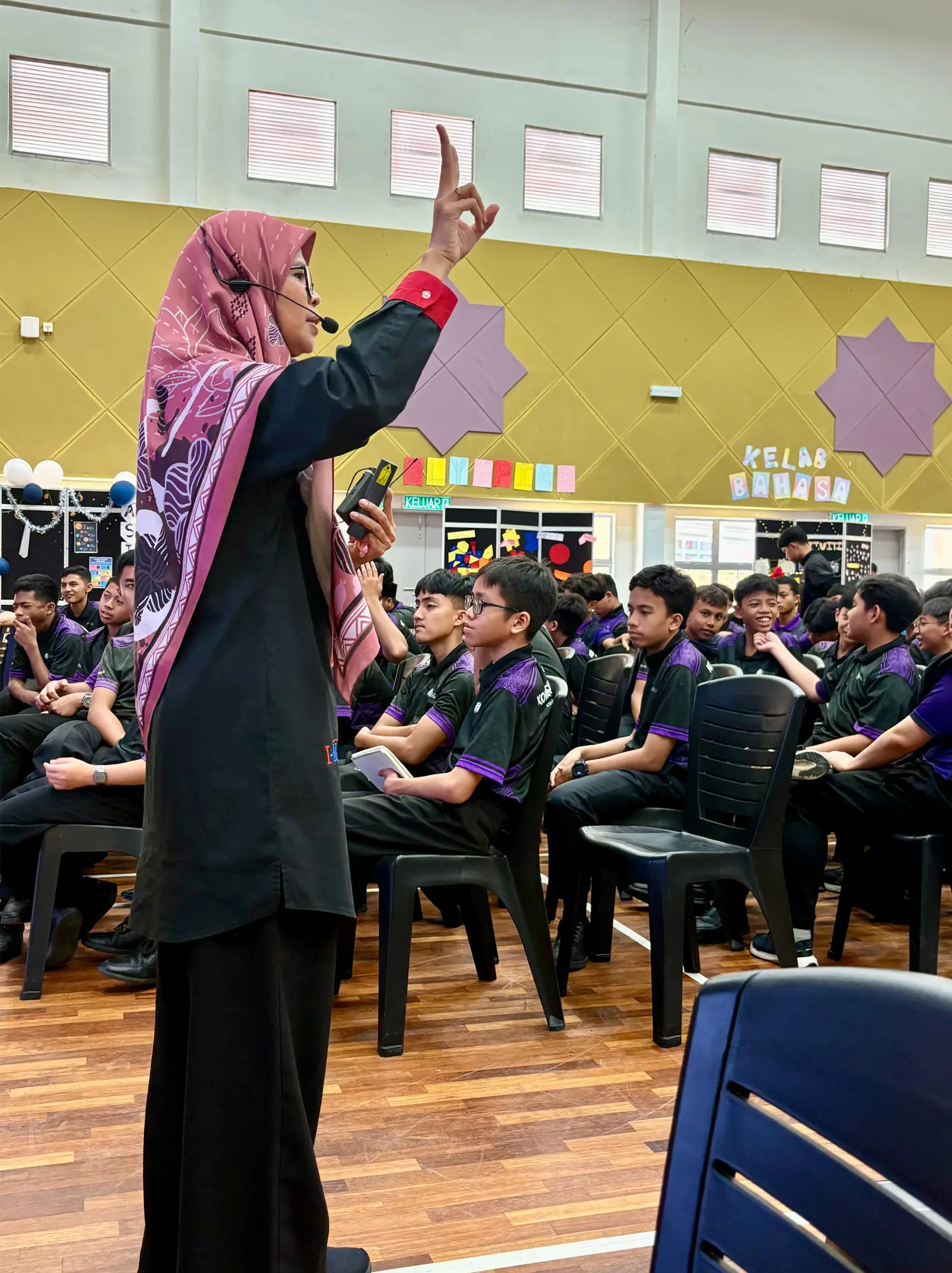 Presenter speaking to students seated in a school hall