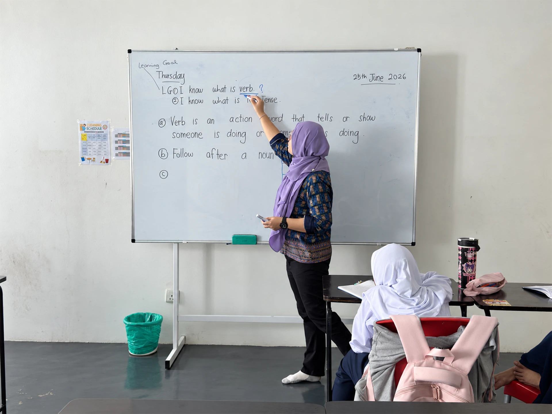 Teacher explaining a lesson at a classroom whiteboard