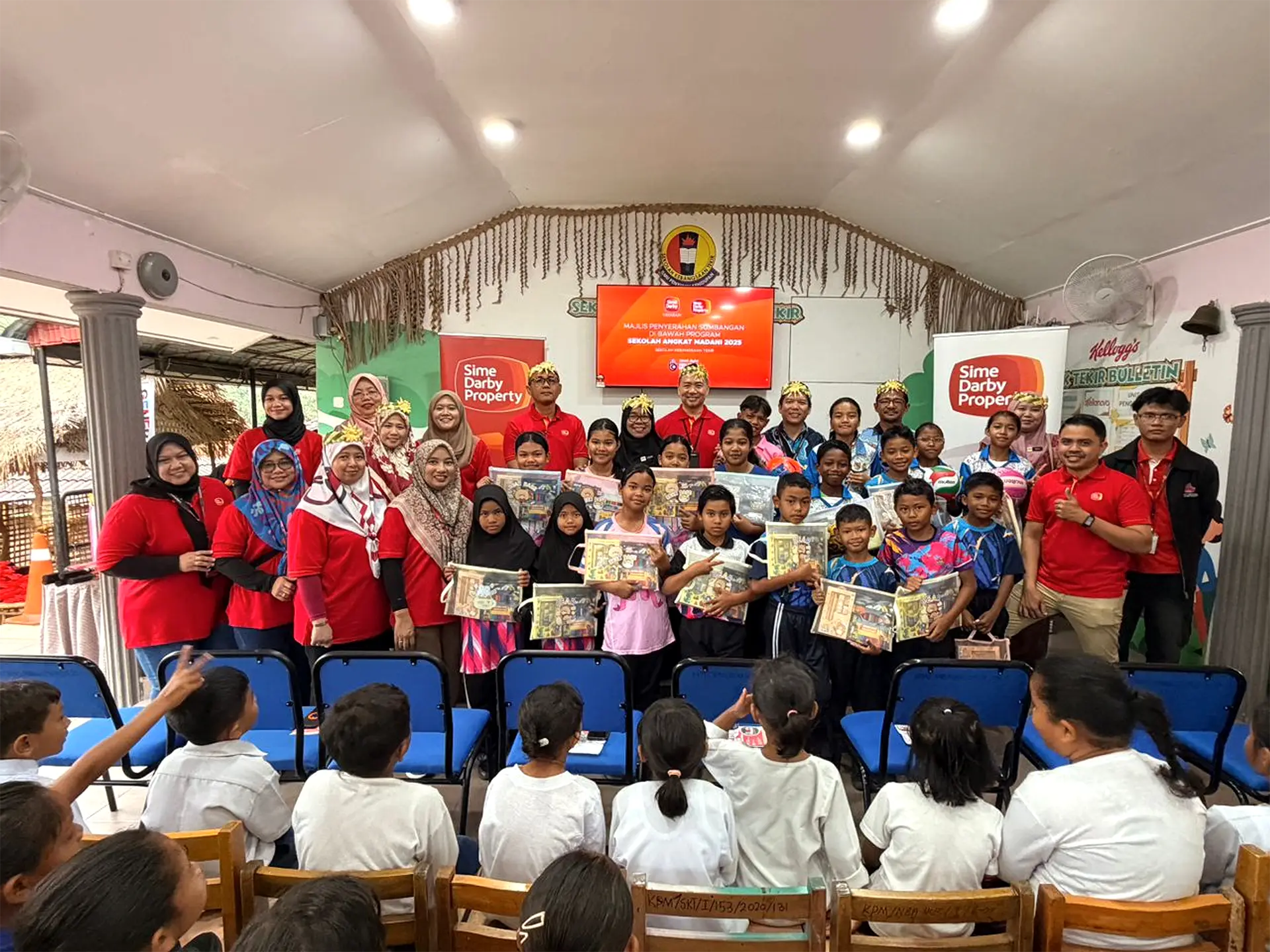Students and adults posing with learning kits at a school event